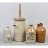 A collection of stoneware to include butter churn, footwarmer and two local advertising flagons.