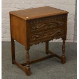 A carved oak chest of two drawers on turned supports.