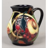 A Moorcroft jug decorated in the Queens Choice pattern, 11cm.