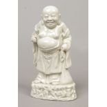 A Chinese blanc de chine figure of Liu Hai. Stood holding a peach in one separately modelled and