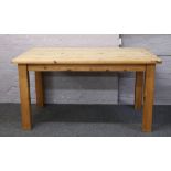 A pine dining table on square cut legs.