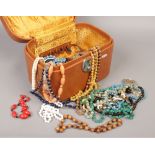 A ladies vanity case containing old bead necklaces.