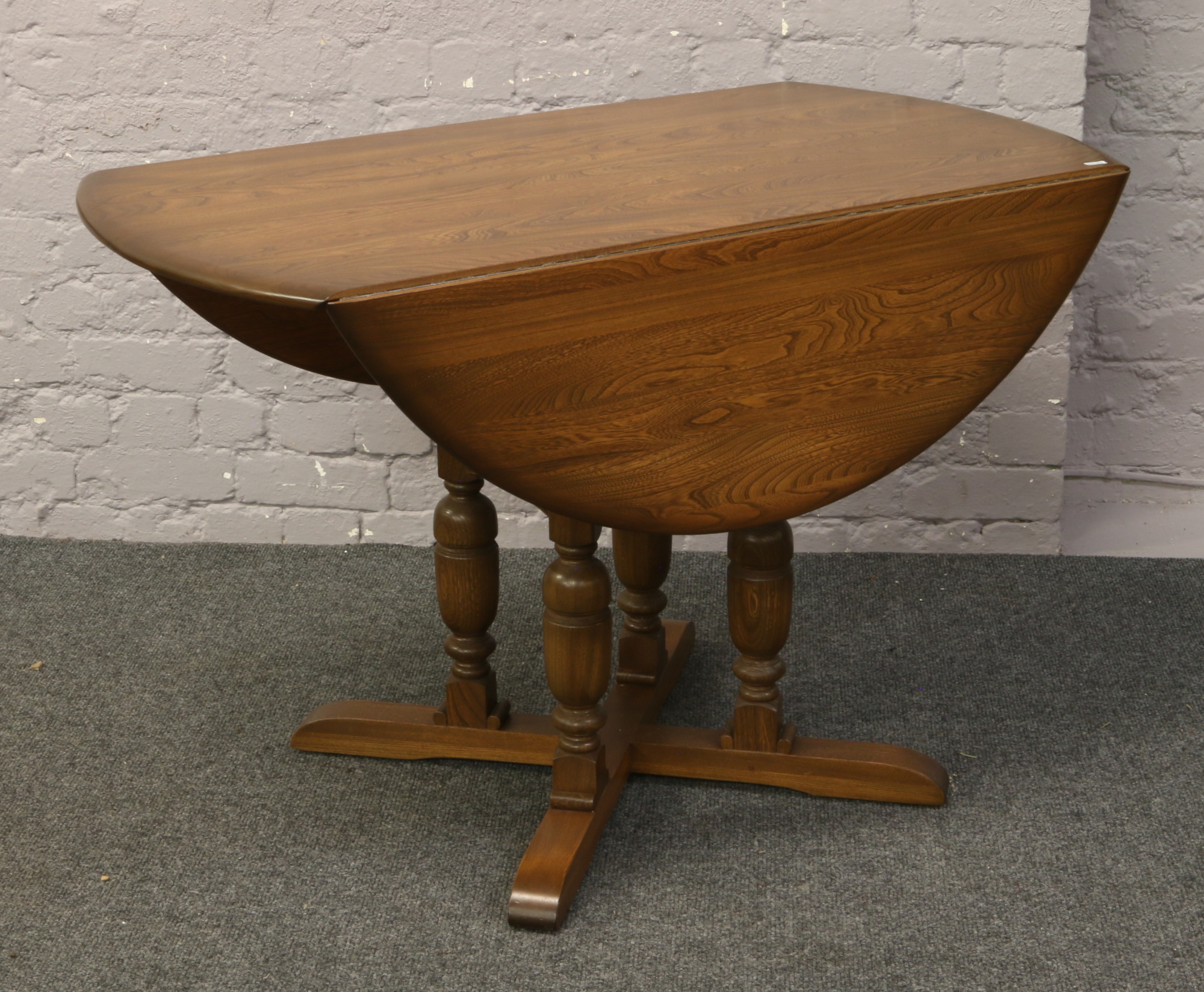 An Ercol Golden Dawn oval drop leaf dining table.