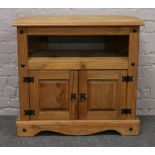 A pine TV stand with cupboard base.