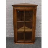 A mahogany wall mounted corner display cupboard.