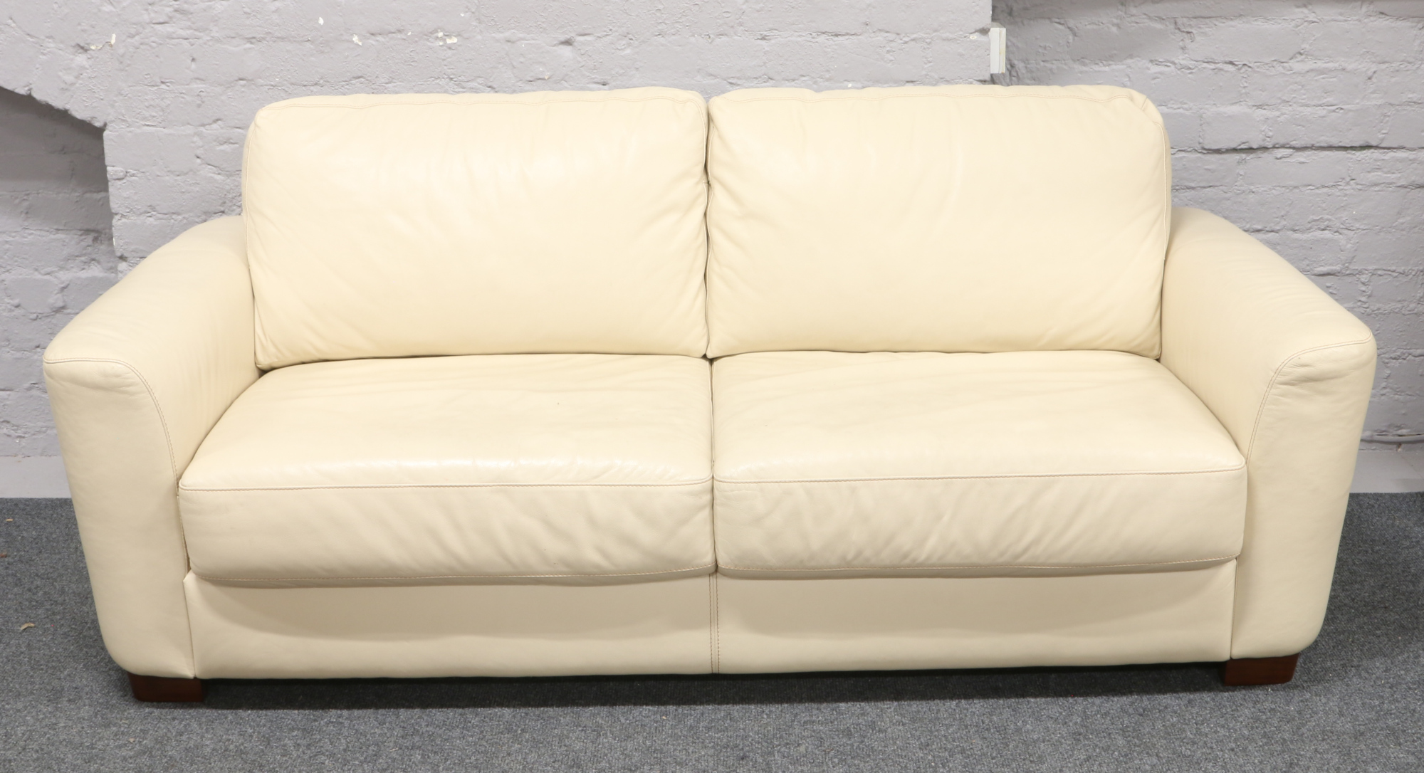 A cream leather three seat sofa bed.