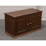 A mahogany linen box with panelled doors.