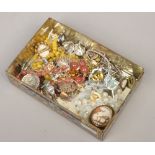 A tin of vintage costume jewellery including enameled RAC brooch, George V silver coin brooch, white