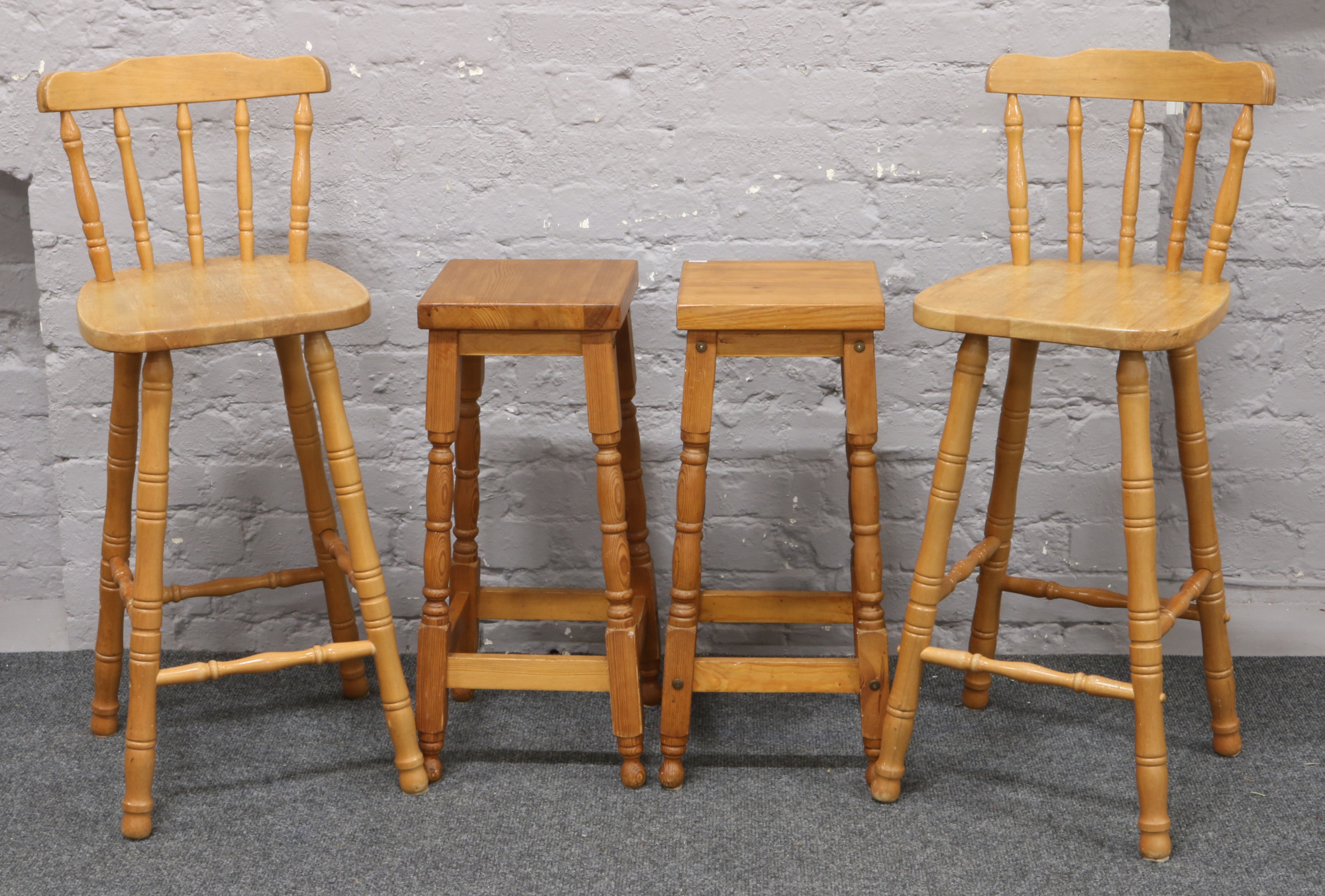 Two pine stools along with two breakfast bar chairs.