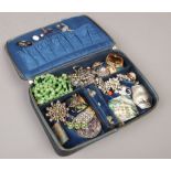 A black ostrich skin dressing case containing mixed costume jewellery including stick pins, white