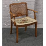 A mahogany bergere seat and back arm chair with woolwork floral cushion.