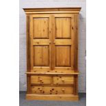 A large pine wardrobe with drawer base H 204cm W 127cm D 64cm.