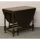 An oak barleytwist drop leaf table with carved decoration.