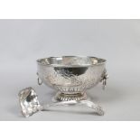 A silver on copper punch bowl with lion head handles along with punch ladle.