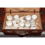 A vintage suitcase with contents of commemorative ceramic mugs to include Staffordshire, Boncath