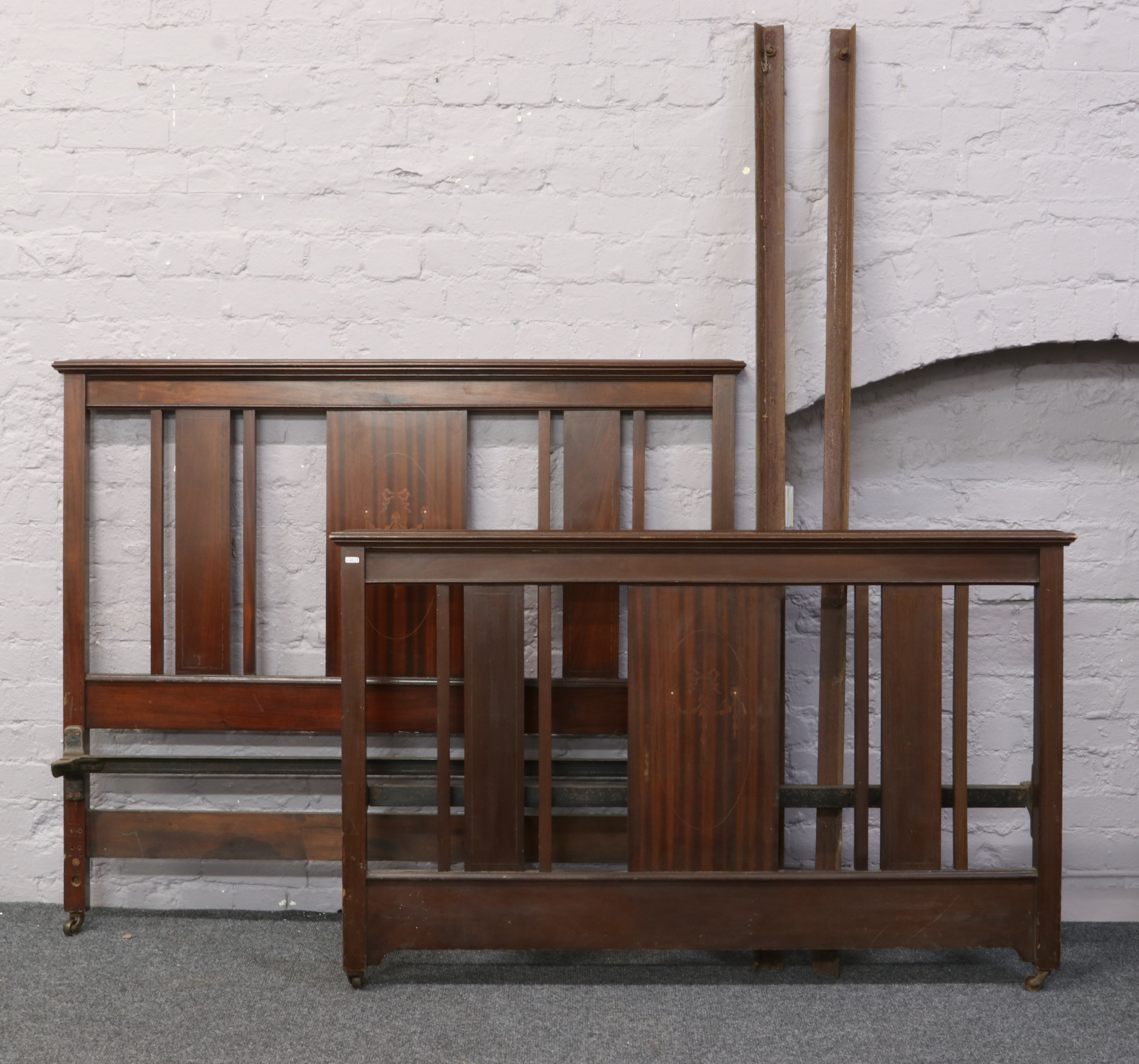 An Edwardian inlaid mahogany double bed frame with irons.