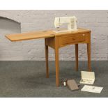 A Bernina Sport 811 treadle sewing machine on oak stand with square tapering supports.