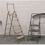 Two sets of folding steel step ladders.