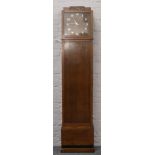 An Edwardian oak long case clock refitted as a bookcase with quartz clock movement.