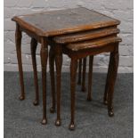 A nest of three burr walnut occasional tables raised on slender cabriole legs.