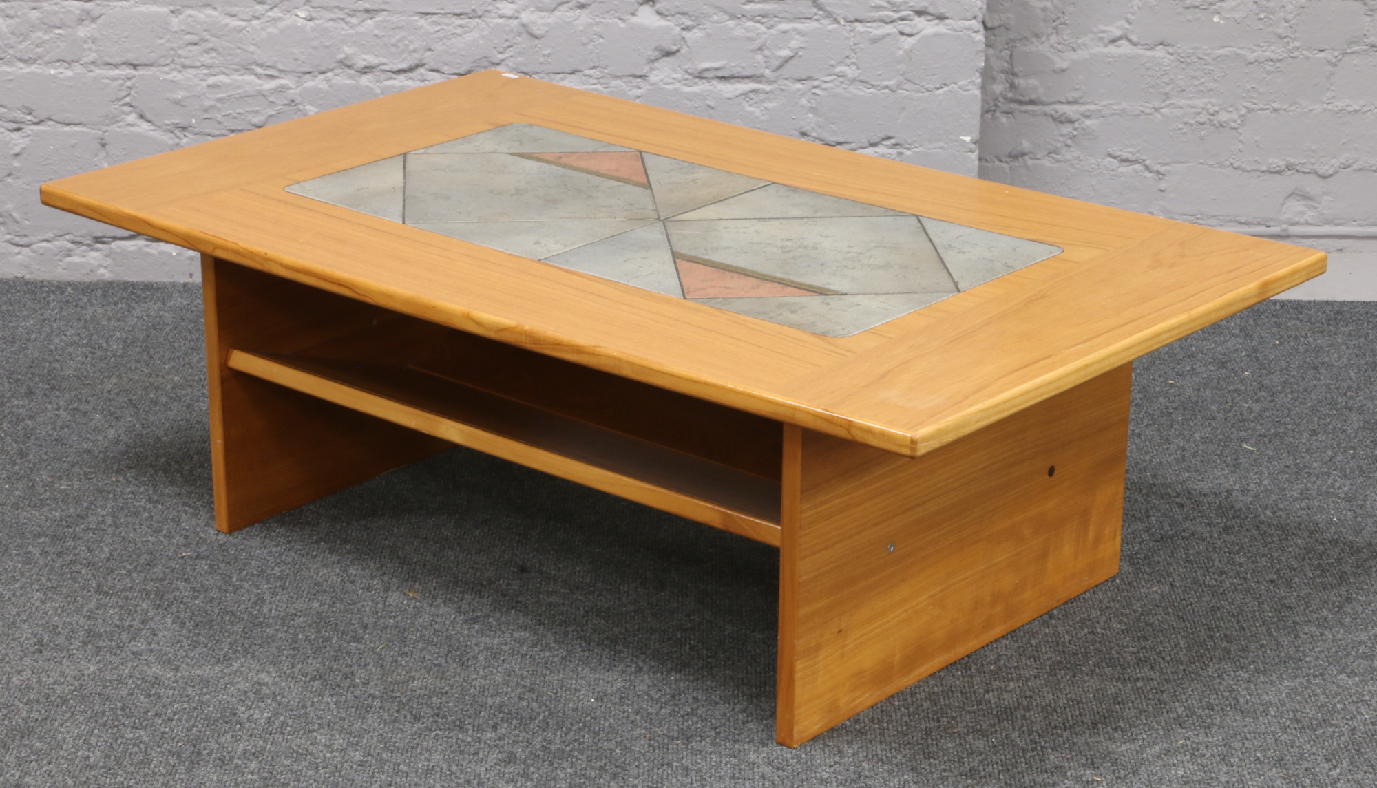 A hardwood two tier coffee table inset with a tile design.