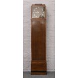 An Edwardian oak longcase clock refitted as a bookcase with quartz clock movement.