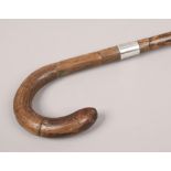 A silver banded walking stick with curved handle, assayed London.