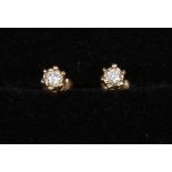 A pair of 9ct gold diamond set ear studs with butterfly backs.