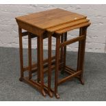 A nest of three quarter veneered occasional tables.