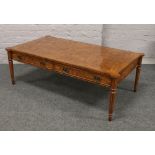 A bur walnut coffee table incorporating four drawers raised on reeded tapering supports, 132cm x