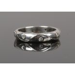 A platinum and diamond 8 stone set eternity ring, the shank cast with undulating design, size H1/