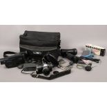 A cased Olympus OM10 35mm camera, cased Kiron 80 - 200 zoom lens, Hitachi video cameras and a