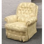 An electric reclining arm chair with cream deep buttoned floral upholstery.
