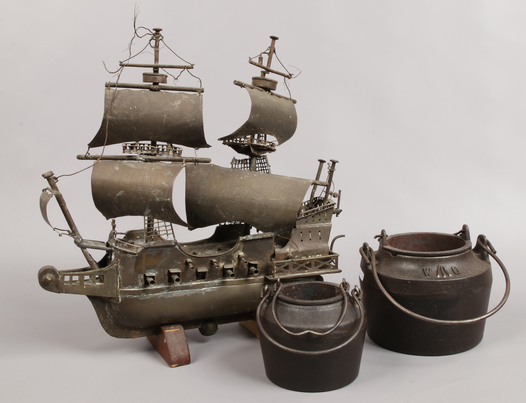 Two Victorian cast iron glue pots, one with broad arrow mark along with a brass model of a galleon.