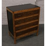 A carved oak chest of four drawers with painted top and sides.