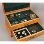 A wood two tier jewellery box with contents of jewellery to include silver examples.