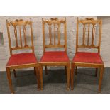 A set of three Edwardian carved back dining chairs raised on square cut tapering legs.