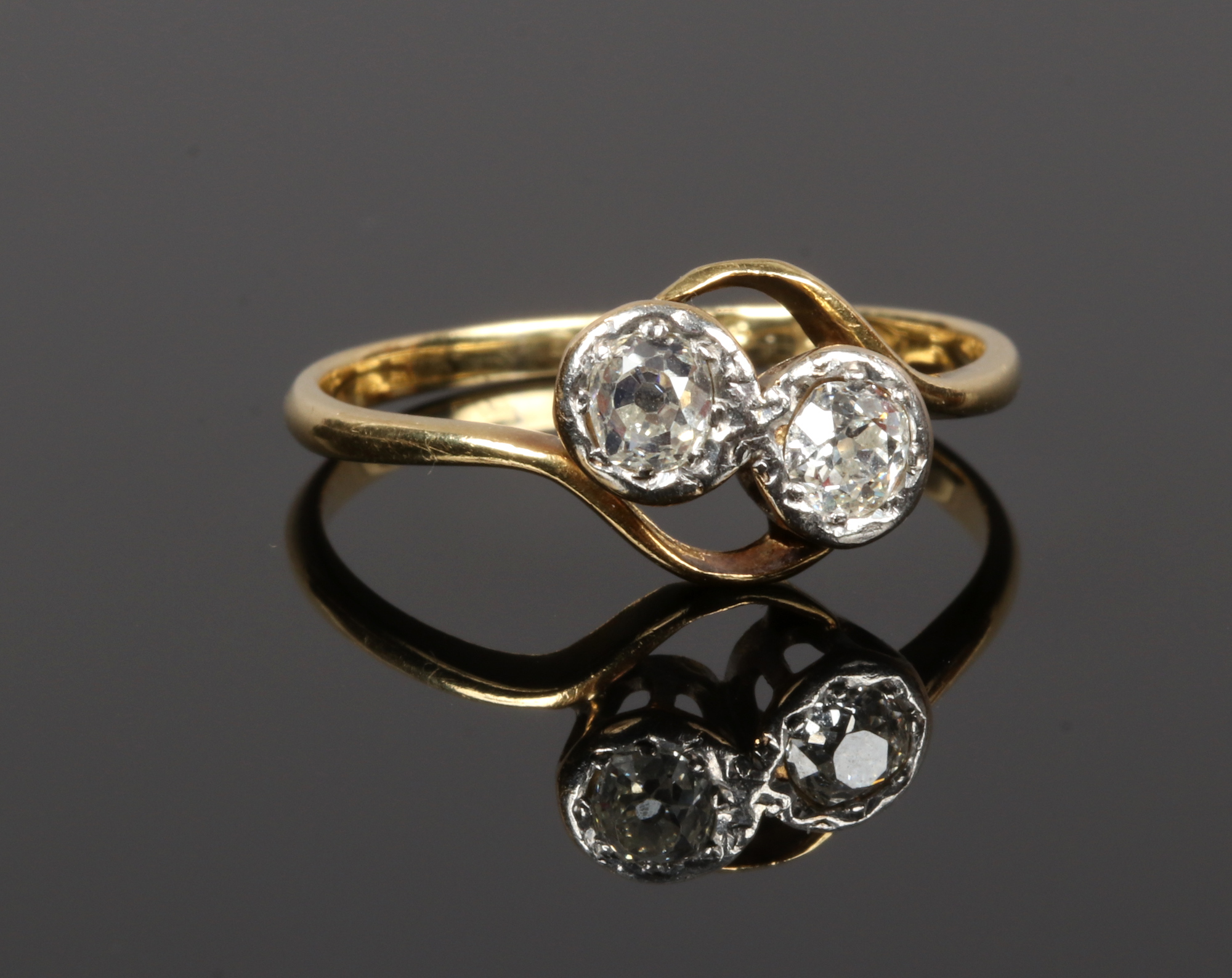 An 18ct gold and diamond two stone cross over ring, set with old European cut stones, stones