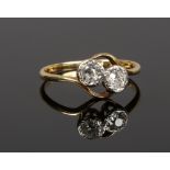An 18ct gold and diamond two stone cross over ring, set with old European cut stones, stones