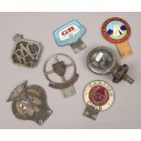 A collection of six vintage automobile radiator badges and an Austin radiator cap.