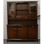 A Stag mahogany wall unit with glazed top, drawer and cupboard base.