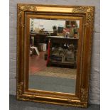A large ornate gilt frame bevel edge wall mirror, 123 x 94cm.