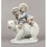 A Lladro figure of polar bear with two Japanese children riding.