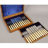 An Edwardian oak cased silver and ivory 12 place set of fish knives and forks, assayed Sheffield