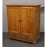 A modern pine cupboard with two drawer base, Height 134cm, Width 113cm, Depth 63cm.
