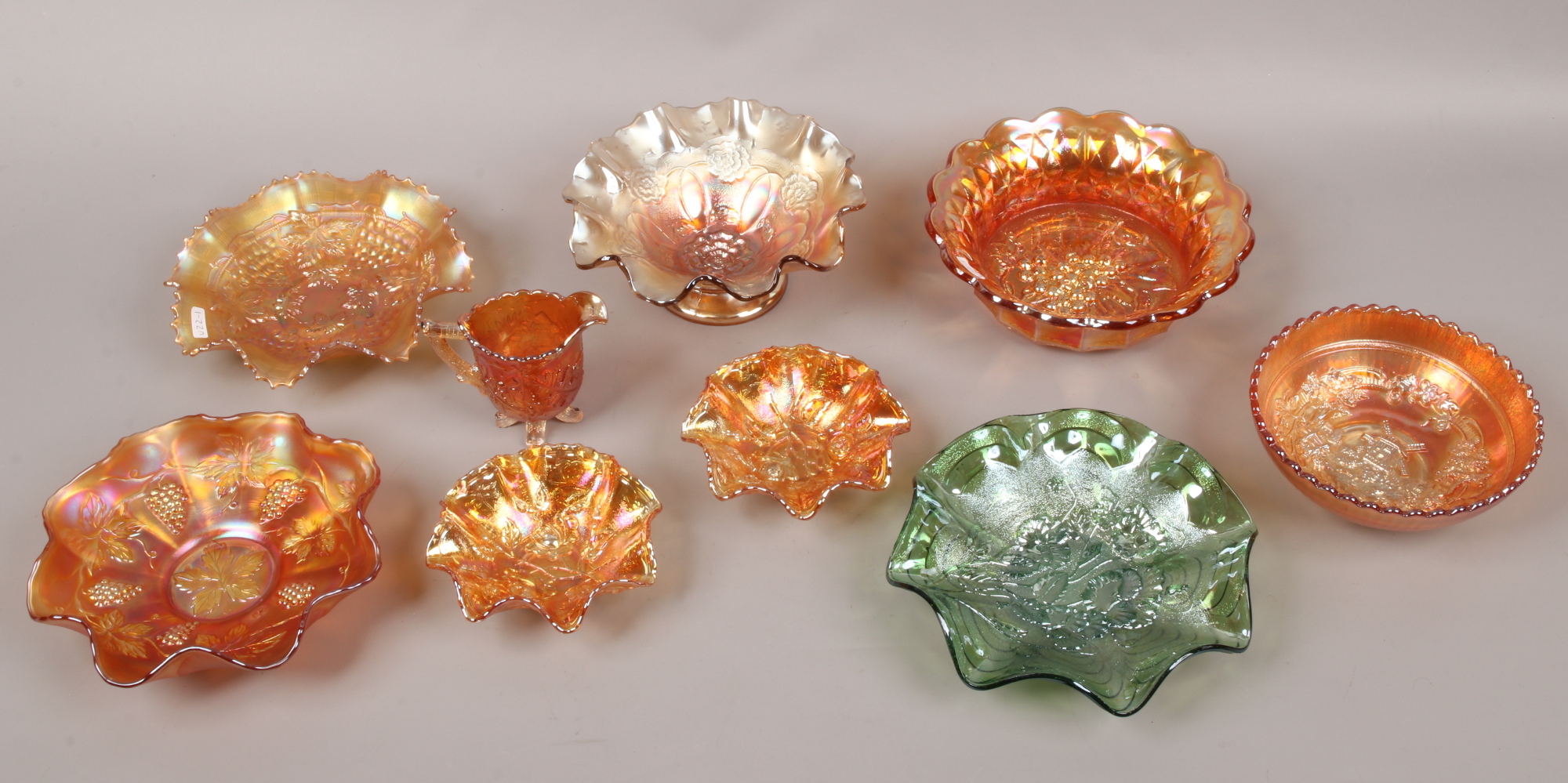 A collection of mainly orange carnival glass, to include one green glass example.