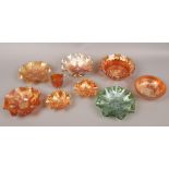 A collection of mainly orange carnival glass, to include one green glass example.