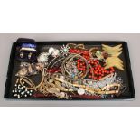 A tray of costume jewellery including white paste set brooches, wristwatches, bangles, rosary