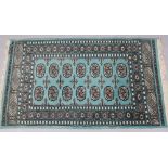 A green ground Bokara rug, 96cm x 162cm.