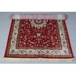 A red ground Kashmir rug with a medallion design, 155cm x 225cm.